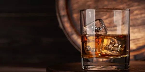 Whiskeyglas framför whiskytunna
